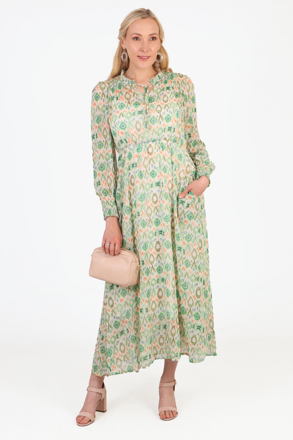 model wearing a long sleeve green dress with an ikat pattern, grandad collar and front tie