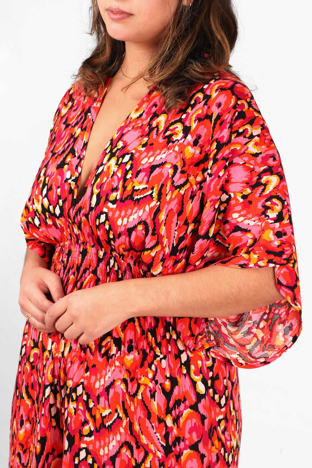 close up of the pink abstract print pattern, shirred waist and plunging v neck