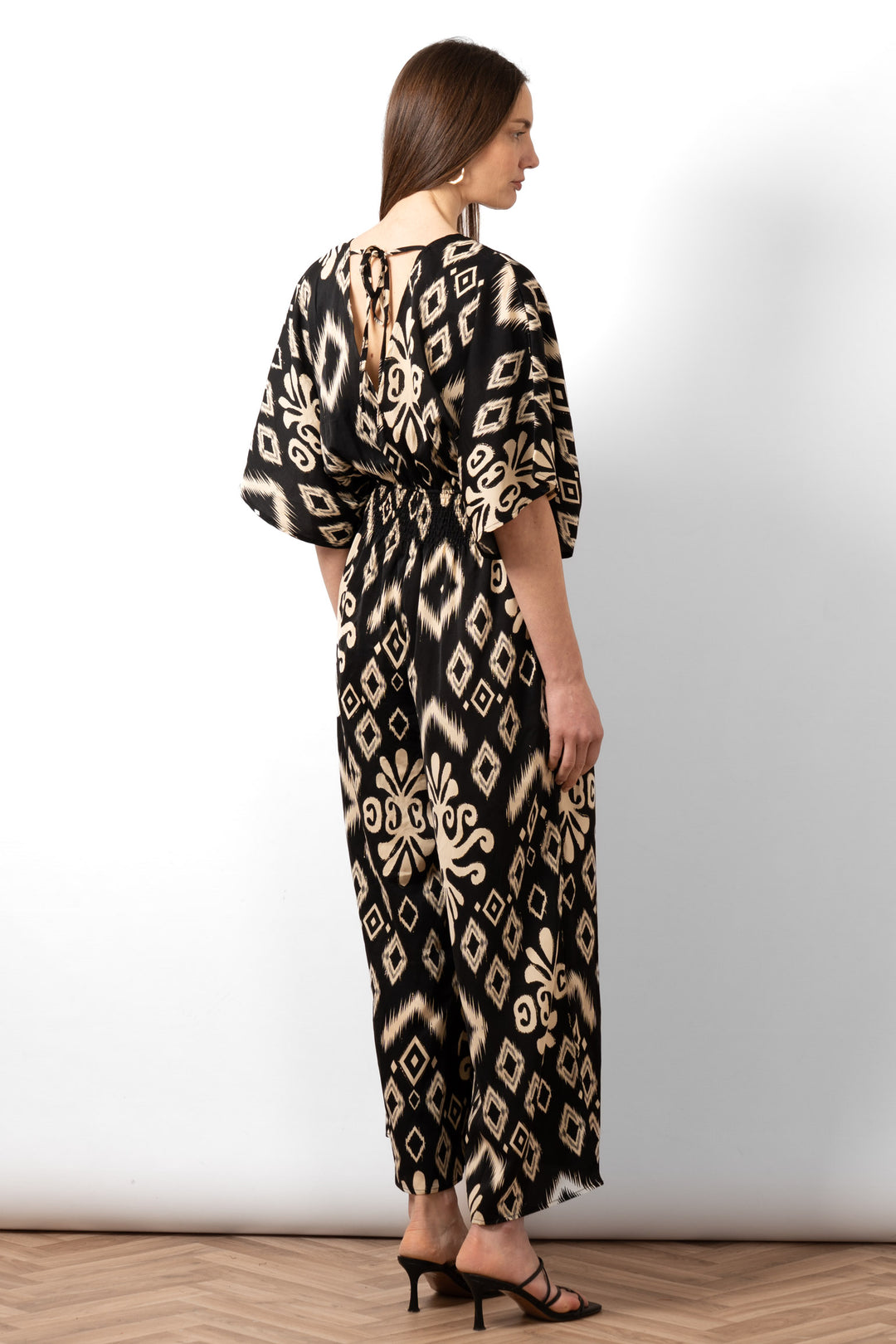 lyra-deep-v-neck-jumpsuit-black-ikat-rear-view-shirred-waist-neck-tie