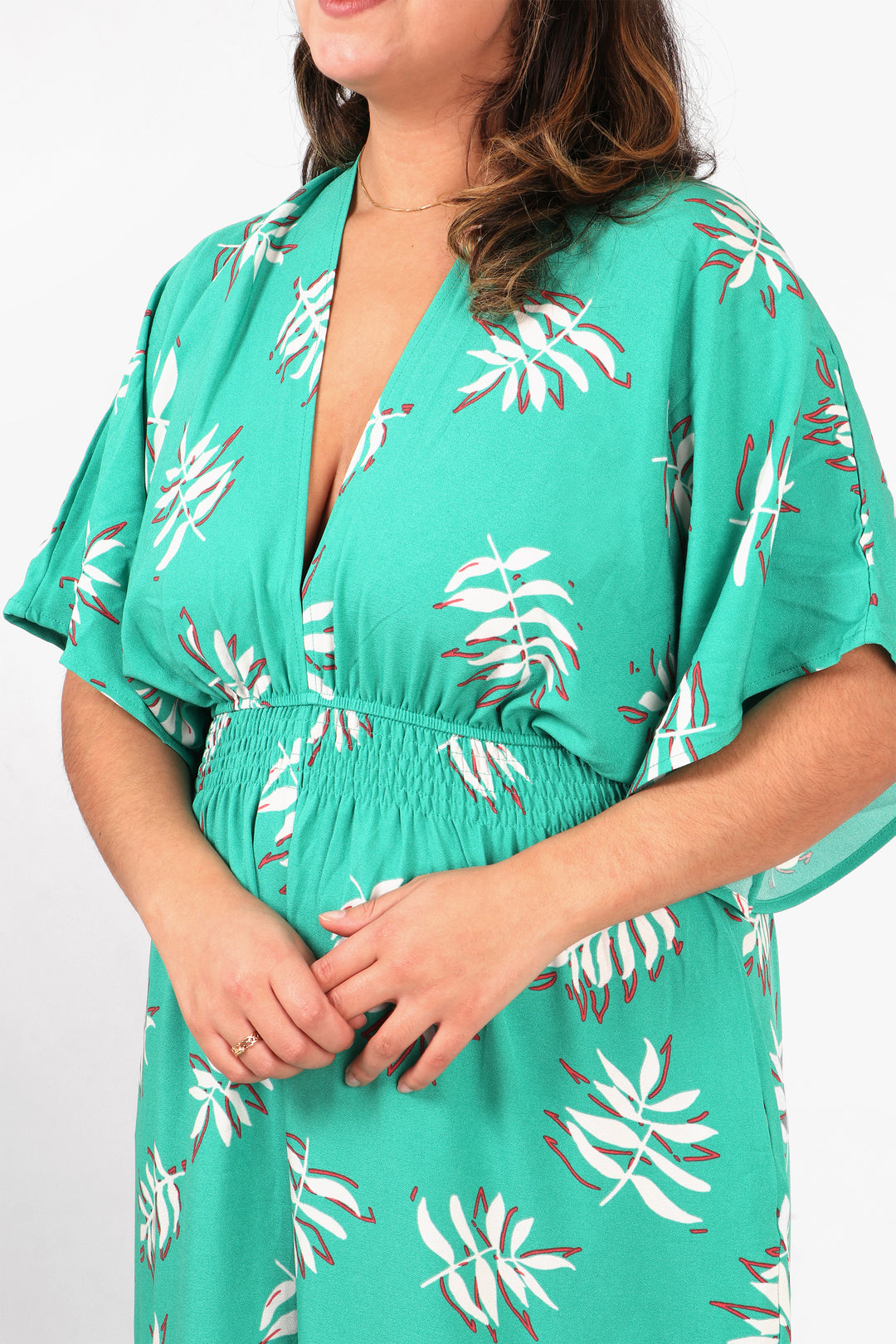 close up of the palm leaf pattern, plunging v neck and shirred elasticated waist on the jumpsuit