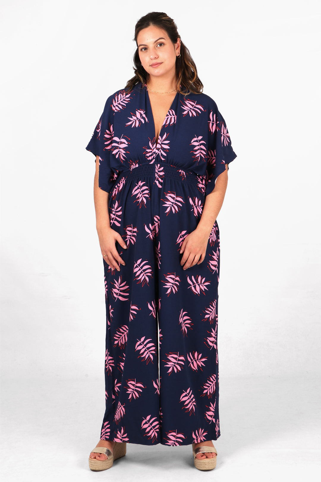 navy blue and pink leaf print wide leg jumpsuit with elbow length short angel sleeves and a deep v neck