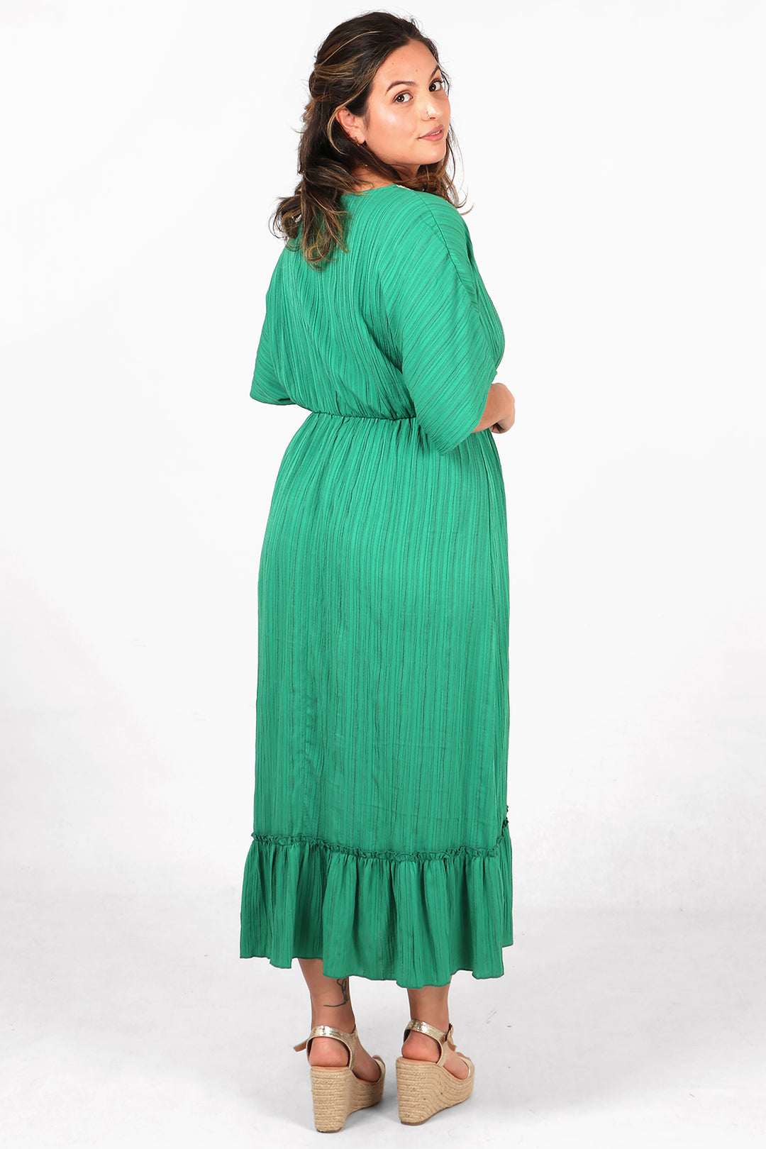 model showing the back of the midi dress, showing an all over green colour with textured fabric