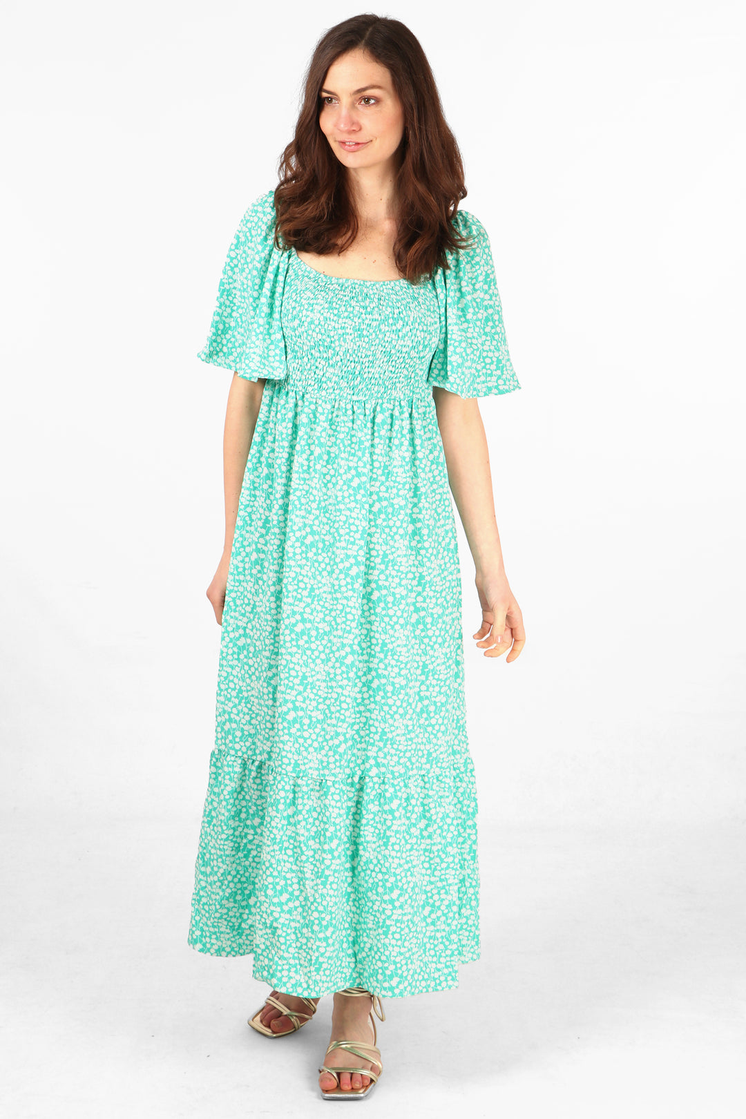 model wearing a green and white ditsy floral maxi milkmaid dress with shirred bodice and short bell sleeves