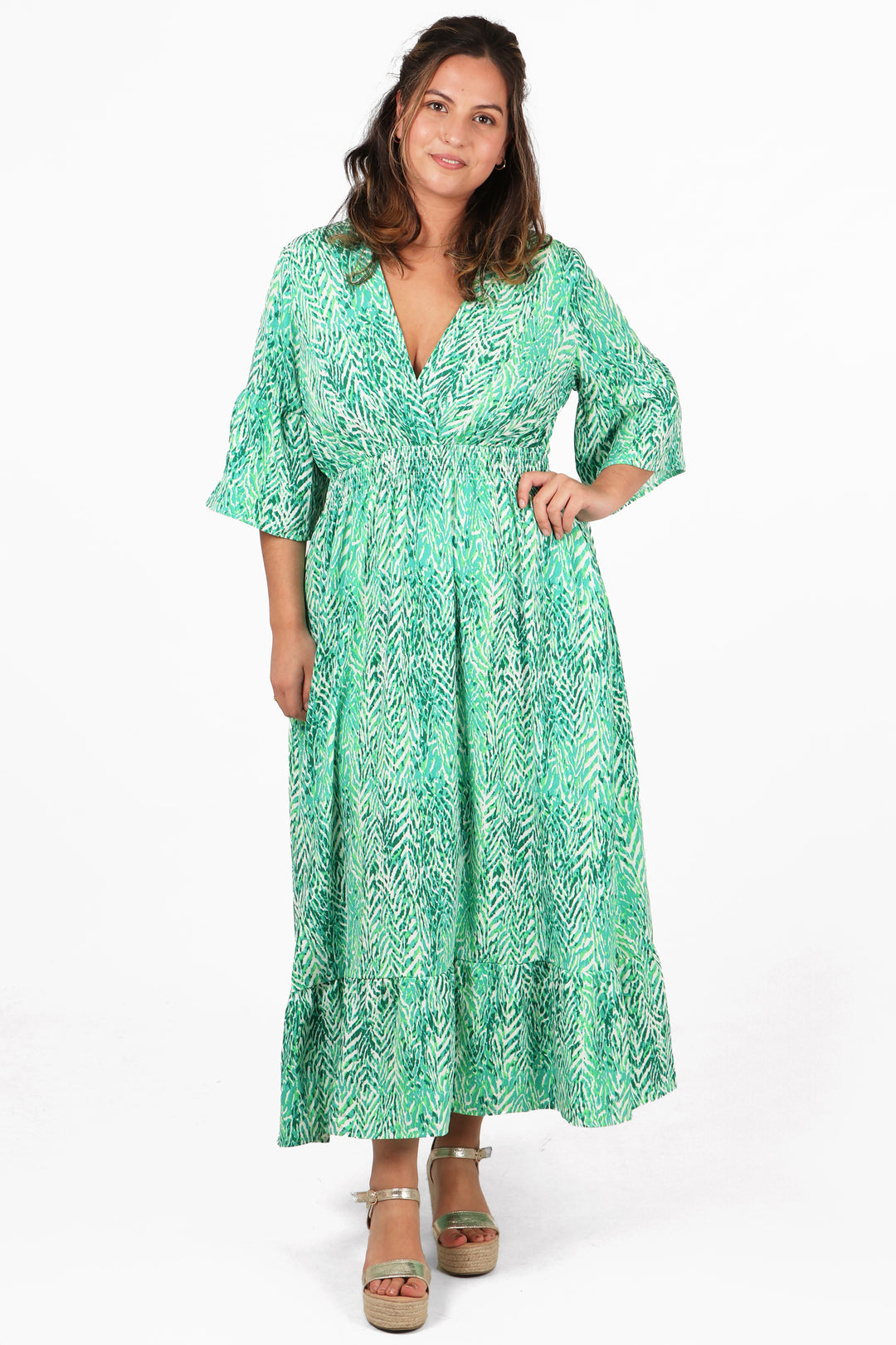 model wearing a green painted chevron print fluted sleeve shirred maxi dress with v neck