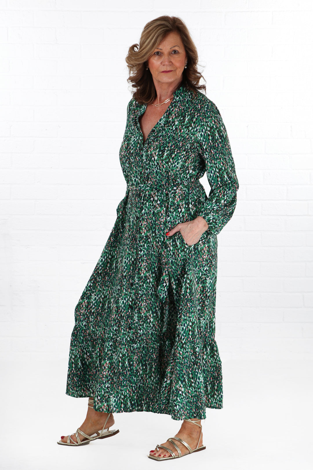 model wearing a green abstract print button down shirt dress with long sleeves and a v neck