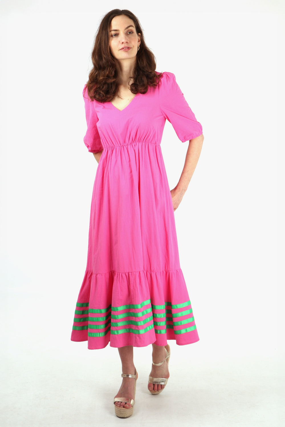 model wearing a pink maxi dress with green stripe details