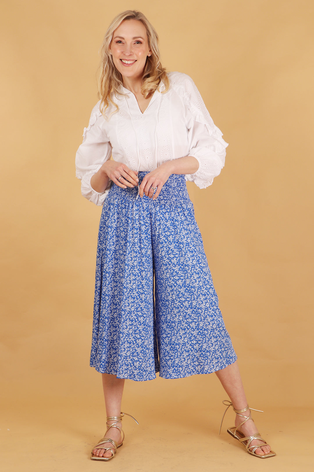 model wearing a pair of midi length blue ditsy floral print wide leg culottes