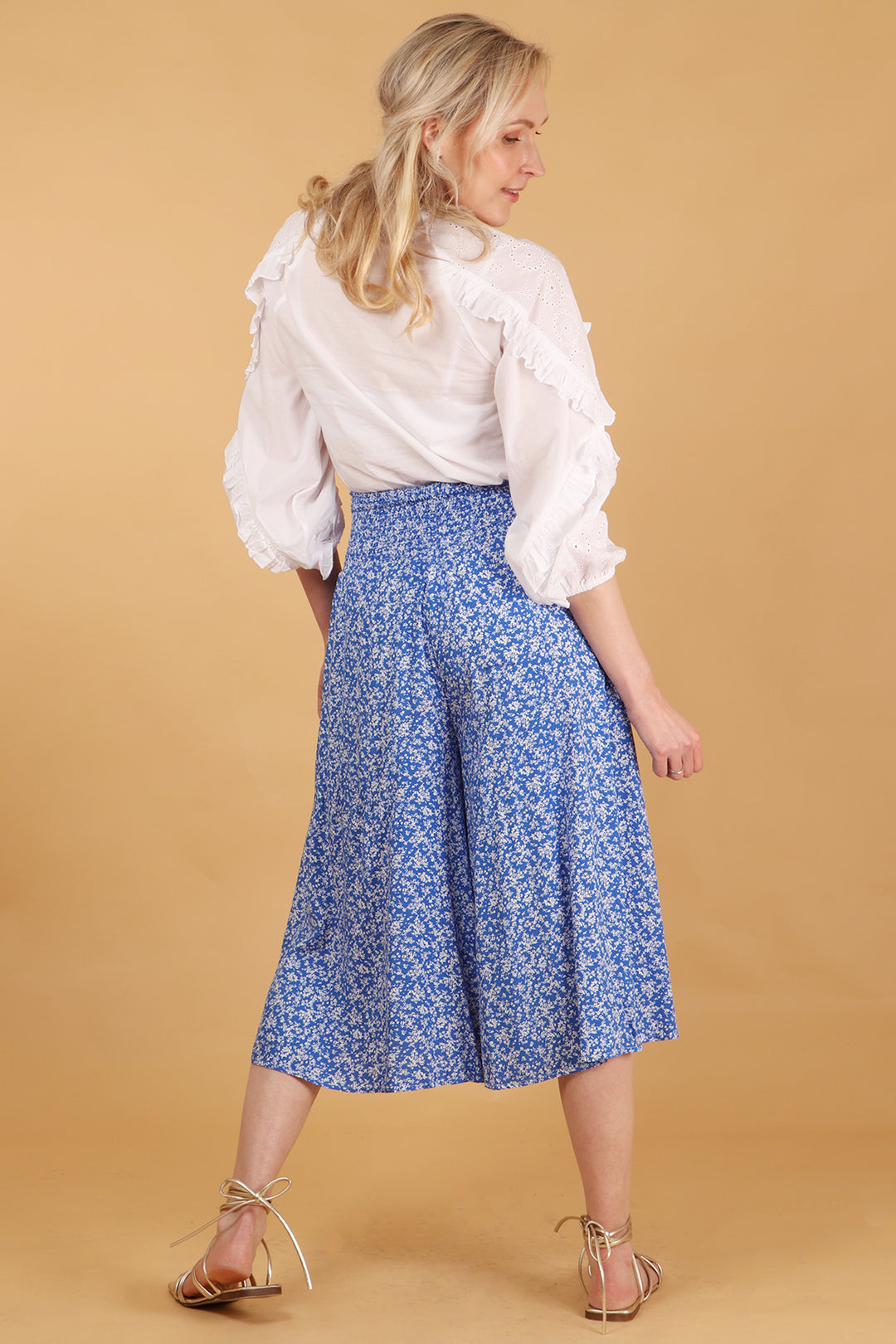 model showing the back of the culottes, showing the all over ditsy floral pattern 