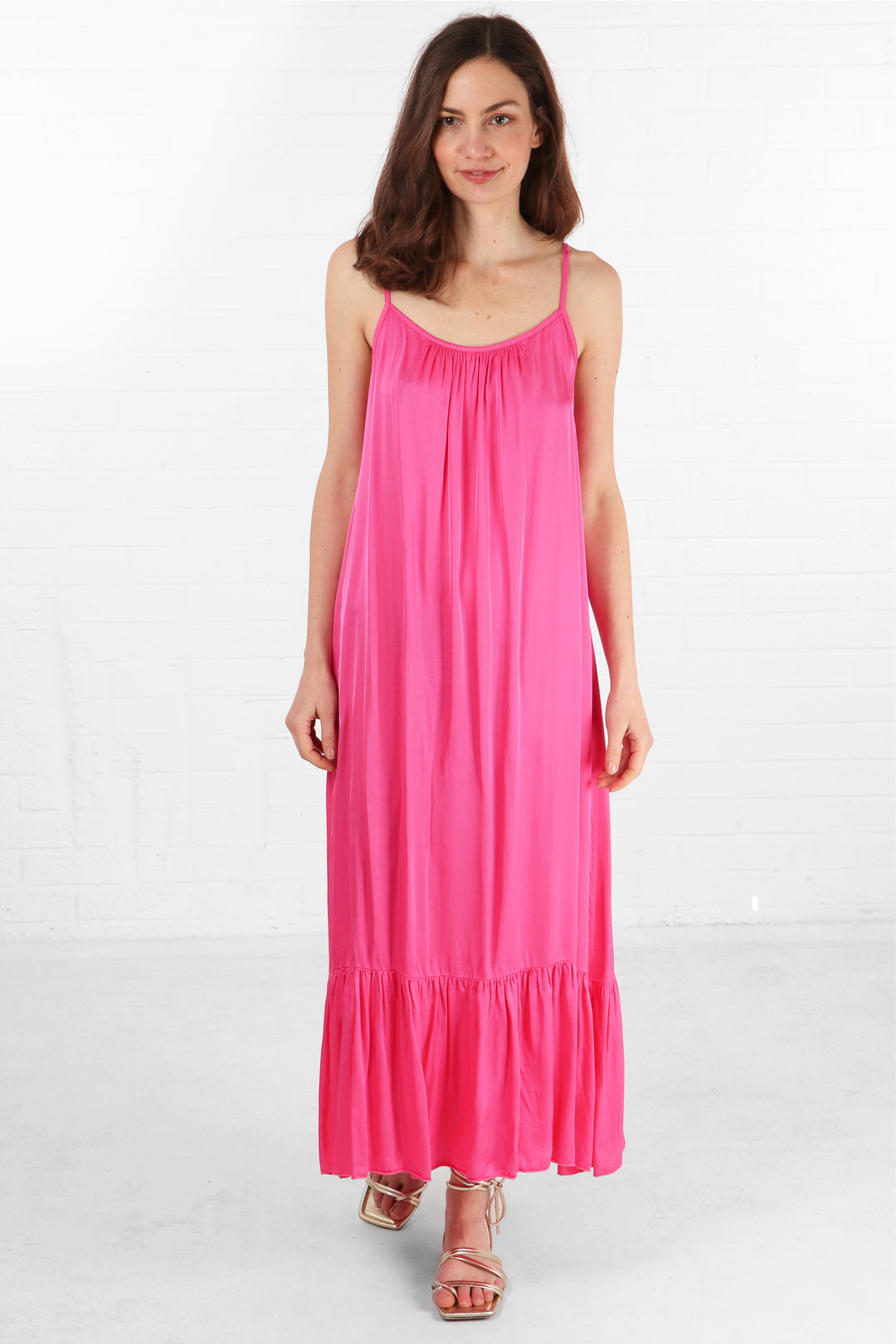 model wearing a hot pink tiered maxi dress with thin spaghetti staps