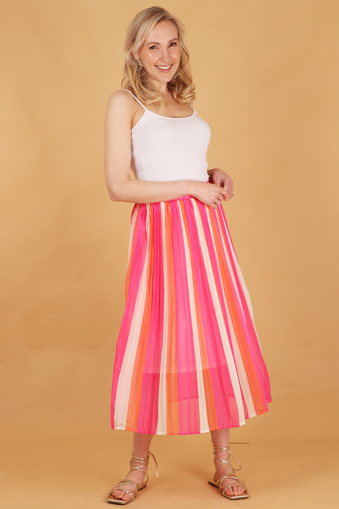 model wearing a pink and coral striped pleated chiffon midi skirt 
