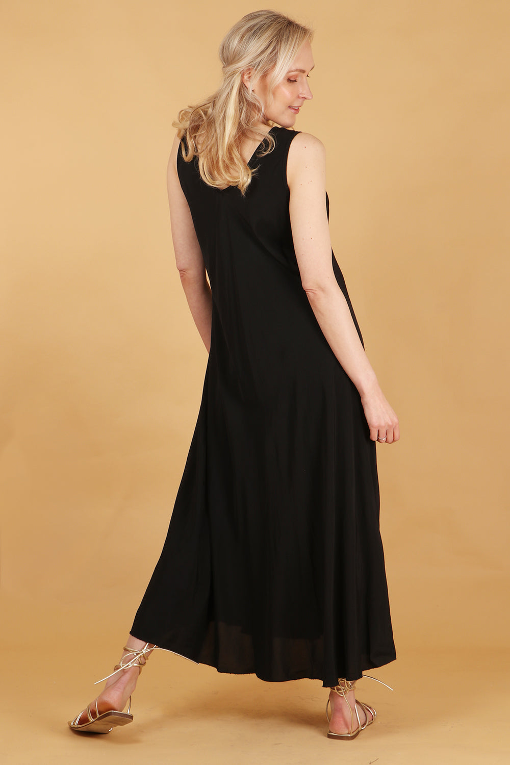 model showing the back of the black maxi dress showing an all over plain black design