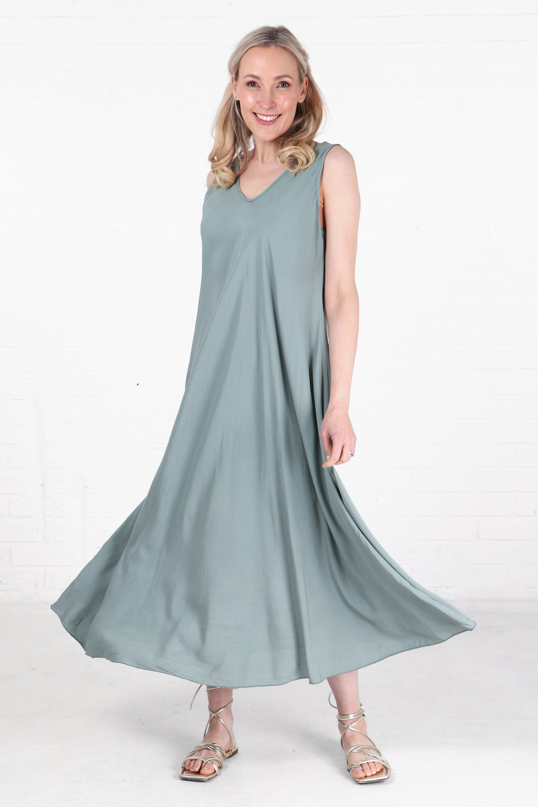 model wearing a maxi a-line v neck trapeze dress in sage green
