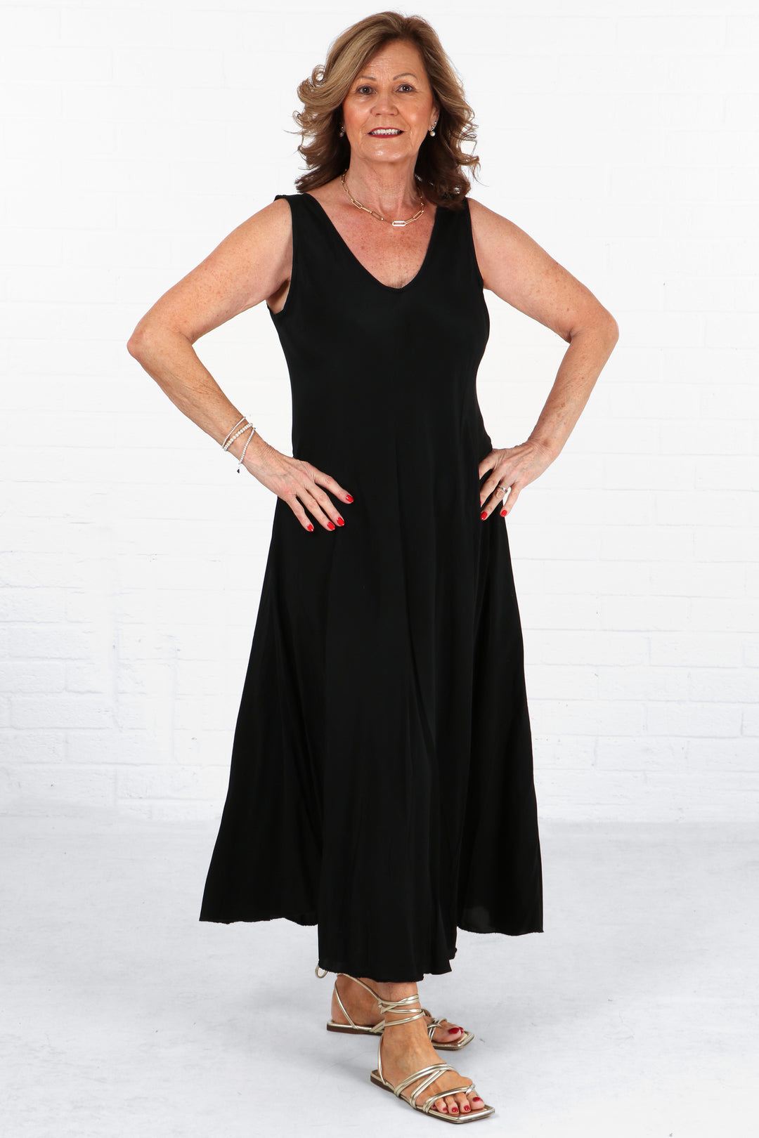 model wearing a maxi a-line v neck trapeze dress in black