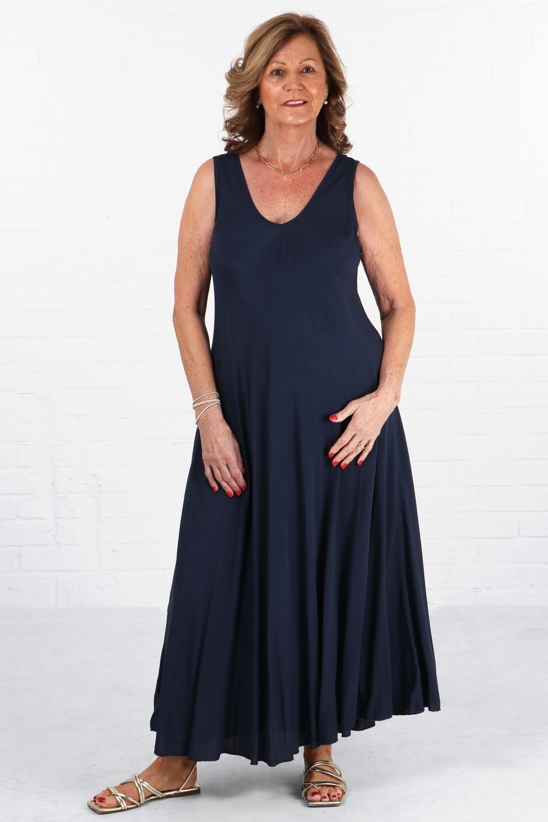 model wearing a maxi a-line v neck trapeze dress in navy blue