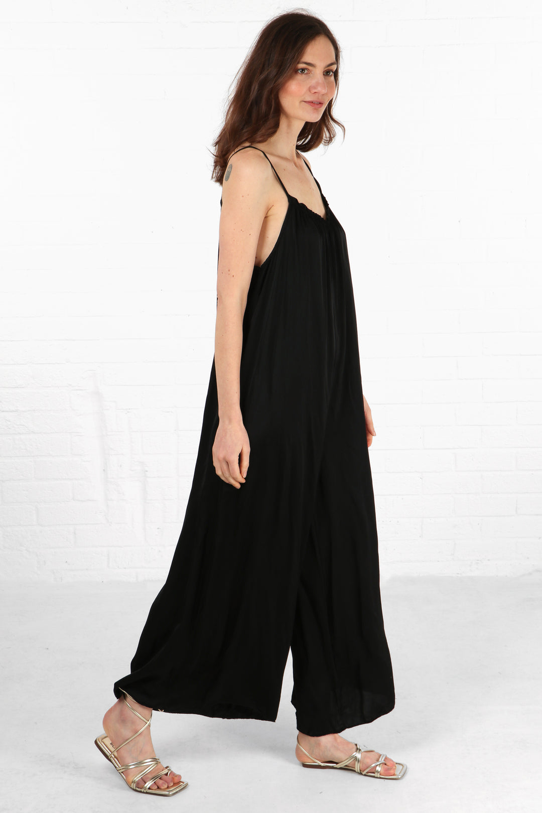 model wearing a loose fitting wide leg strappy jumpsuit 