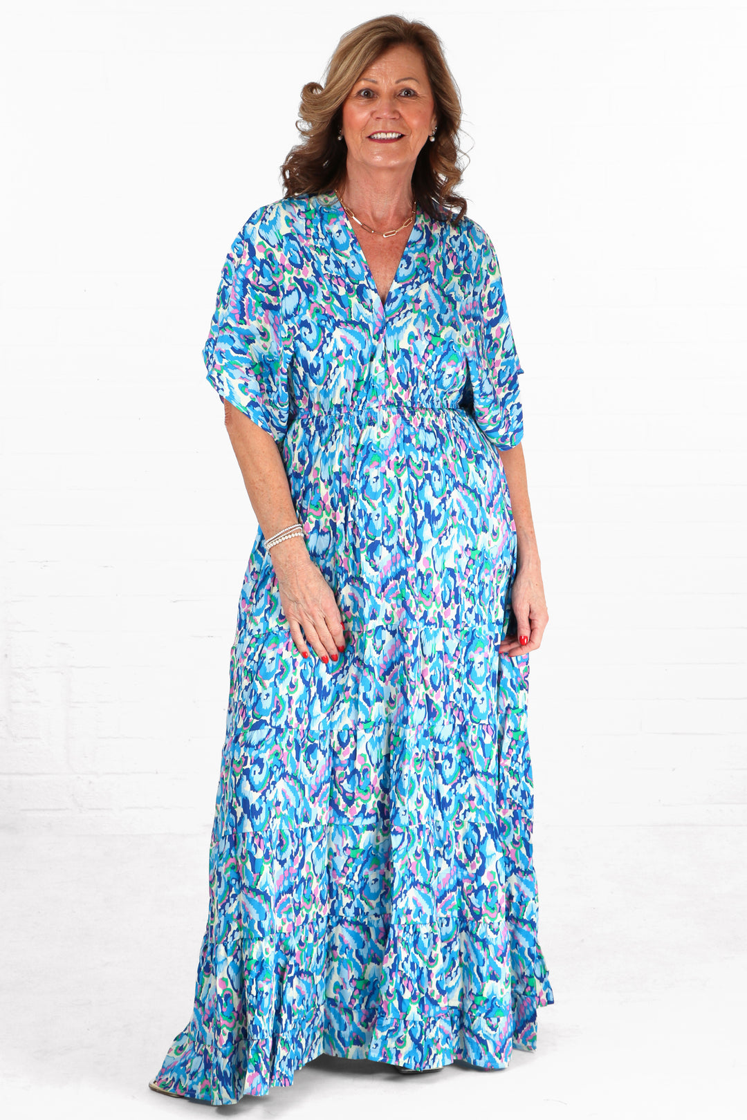 model wearing a blue abstract print maxi kaftan dress with short sleeves and a v neck