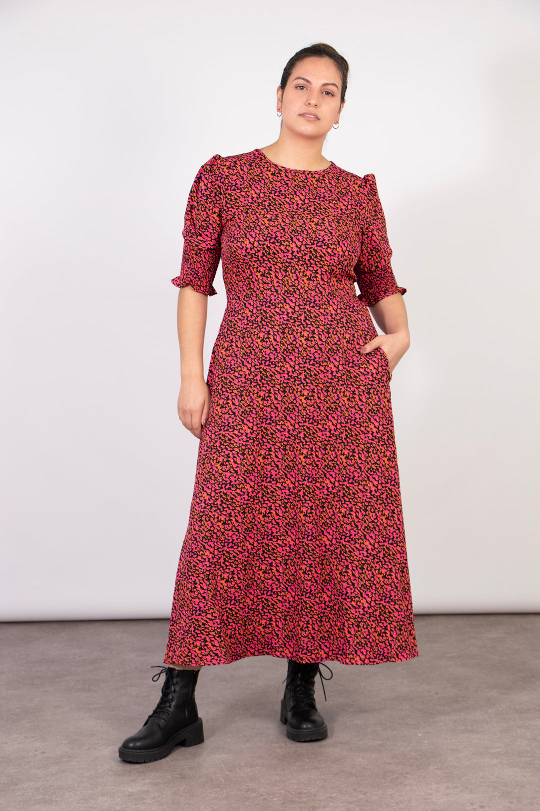 model showing that the abstract print tea dress has pockets on the side of the design