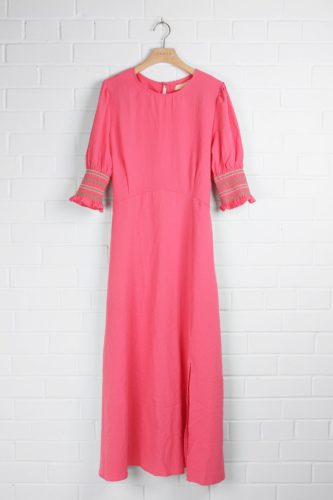 pink tea dress with green embroidered shirred cuff sleeves and a round neck