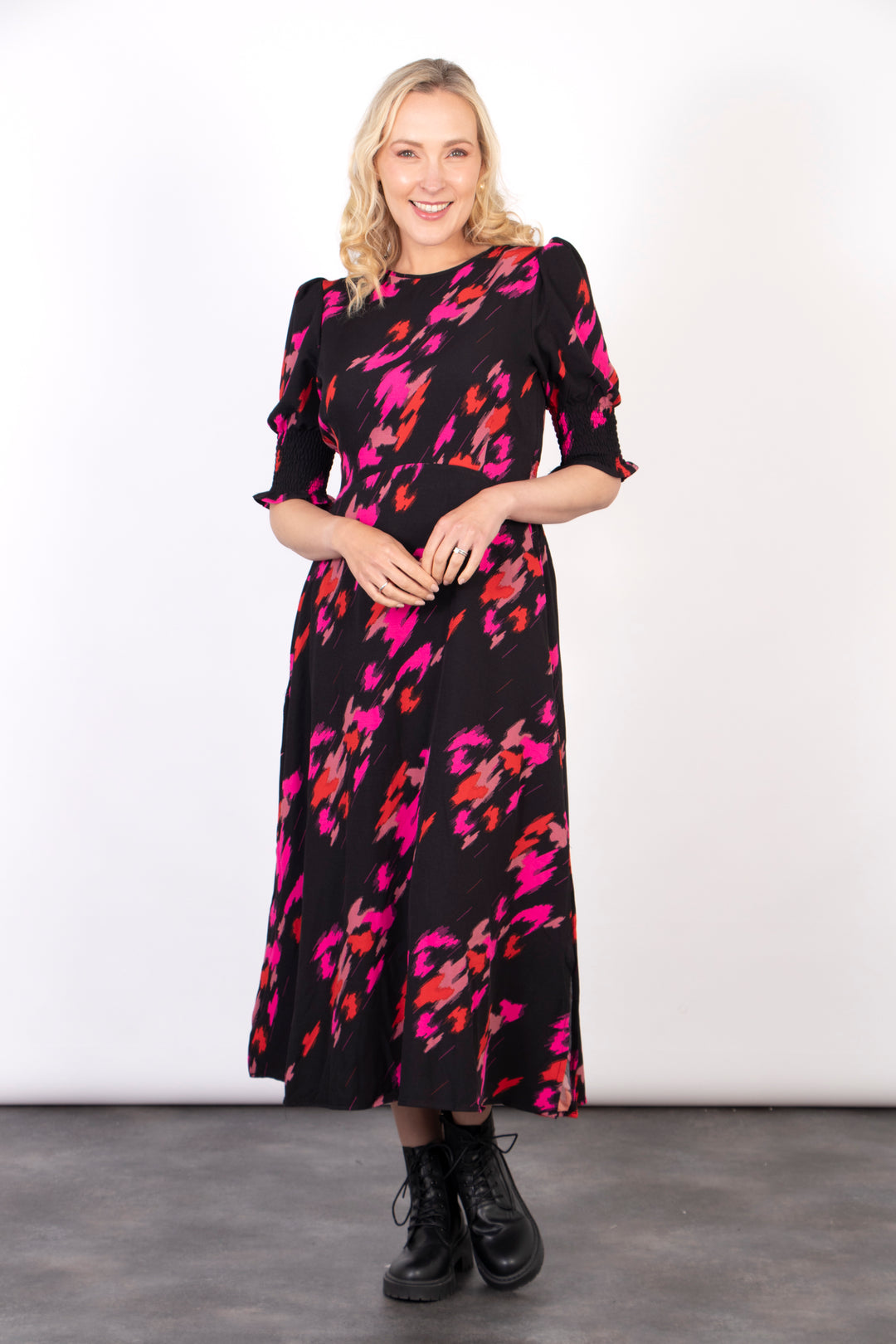 black tea dress with a bold pink abstract animal print pattern all over, the dress has a round neck and 3/4 sleeves