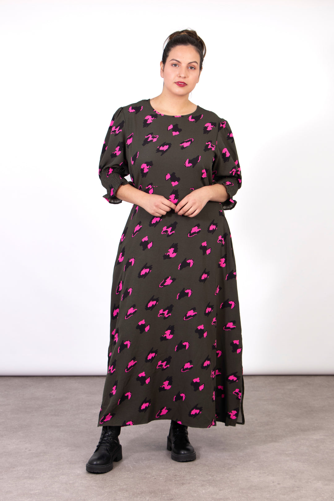 model wearing a khaki green and fuchsia pink leopard print tea dress with 3/4 sleeves and a round neck