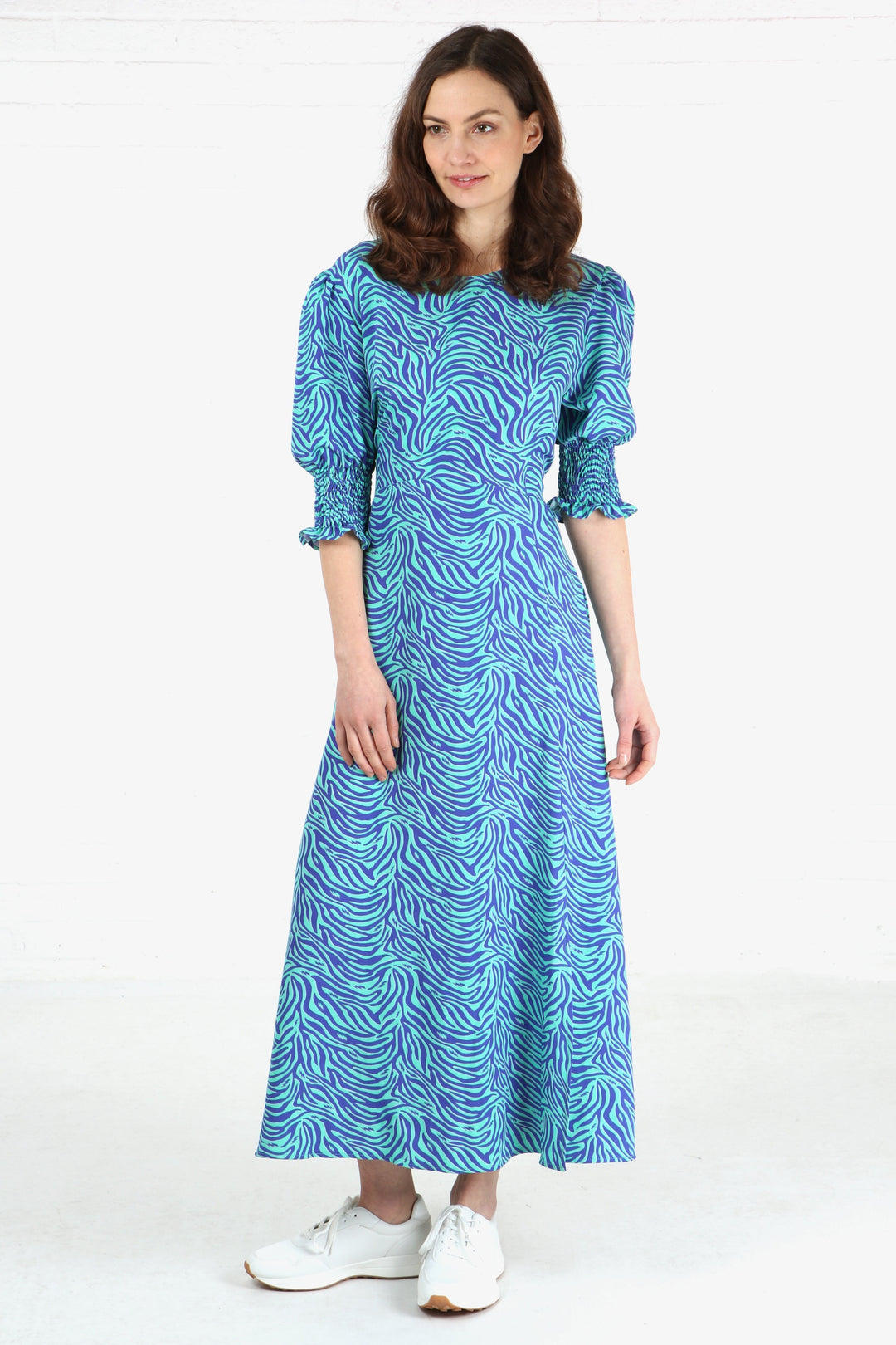 model wearing a blue zebra and lightning bolt  print midaxi length dress with 3/4 sleeves with shirred cuffs