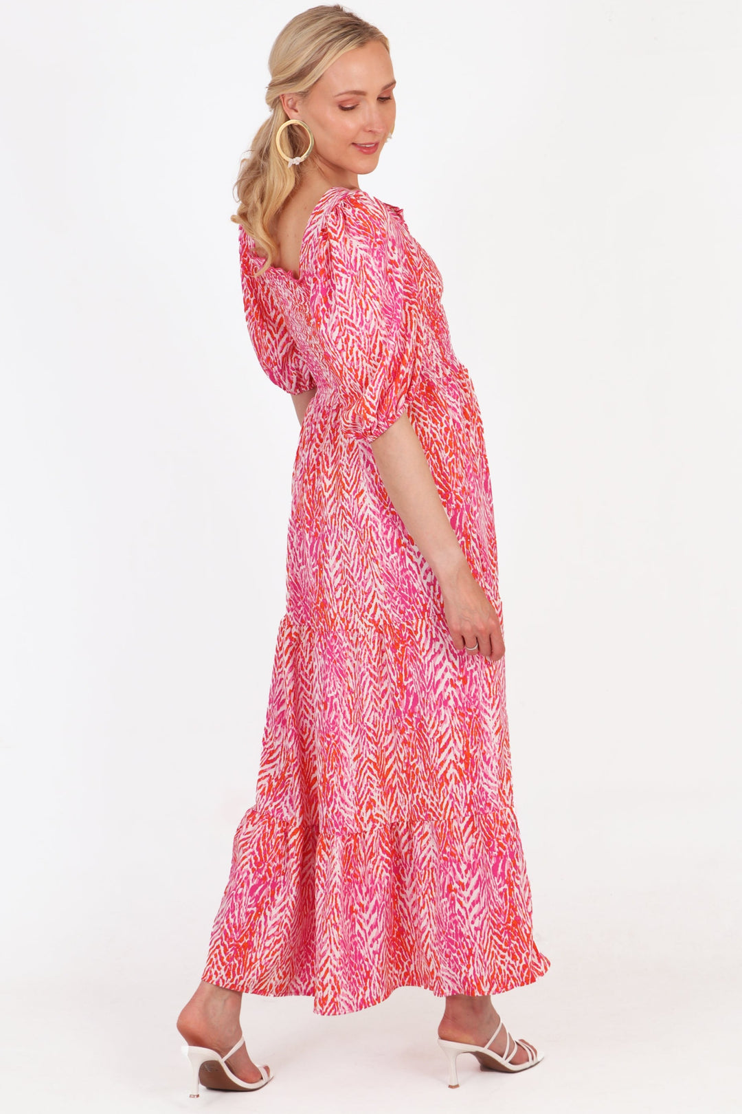 model showing the back of the dress, highlighting the maxi length tiered hem