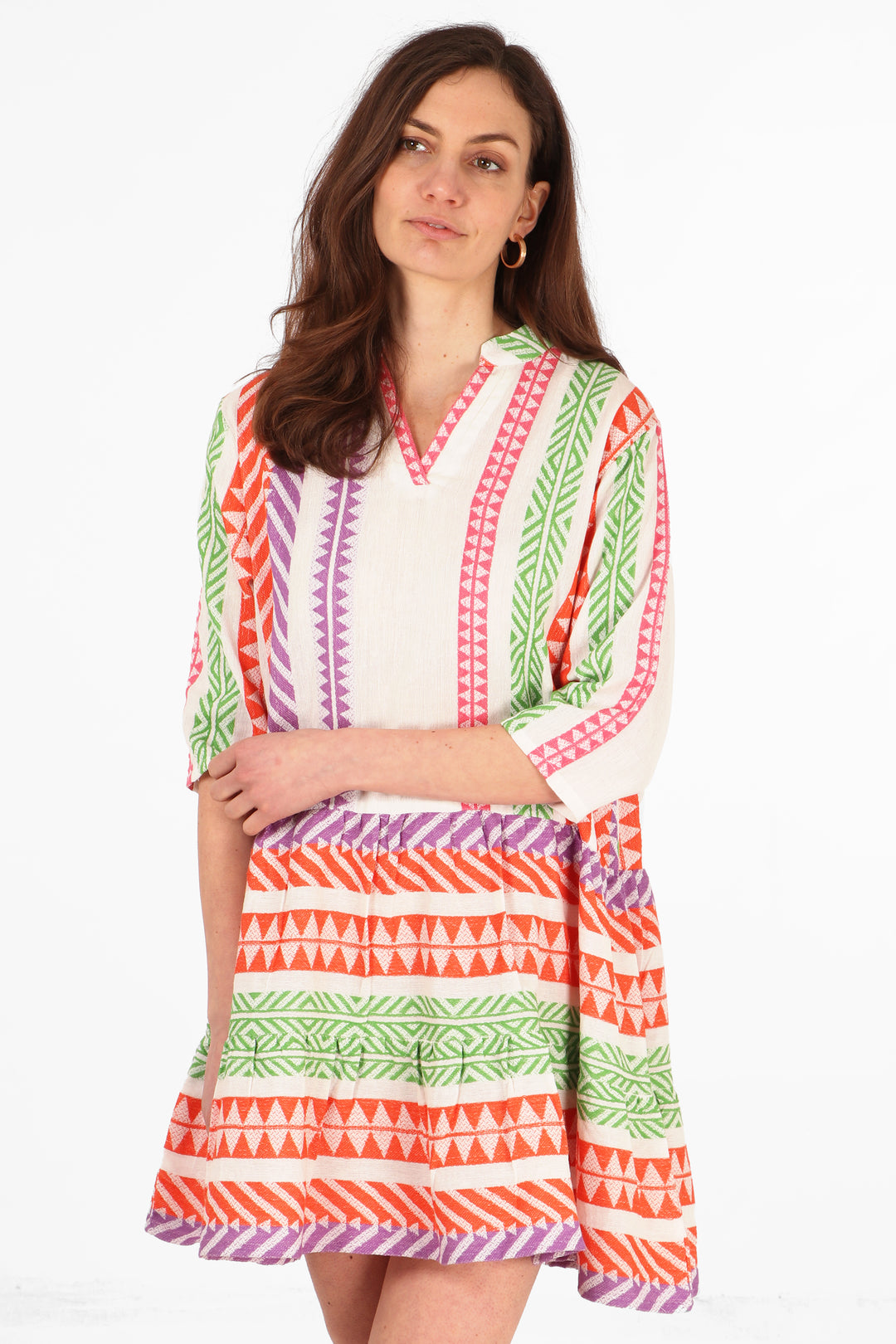 model wearing a multicoloured, orange, pink, purple, green and creammidi dress with an aztec print pattern and 3/4 sleeves
