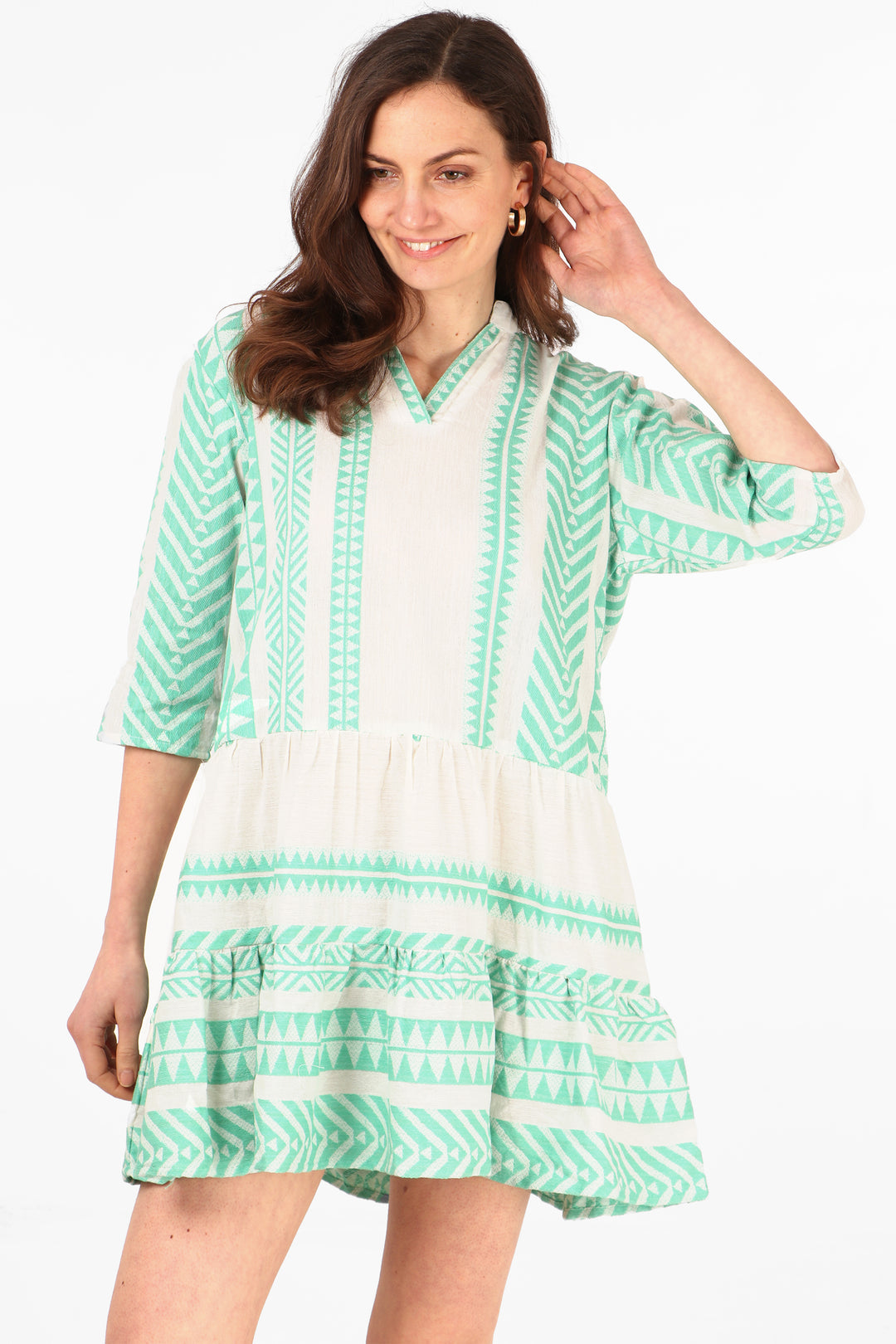 model wearing a cream and light green midi dress with an aztec print pattern and 3/4 sleeves