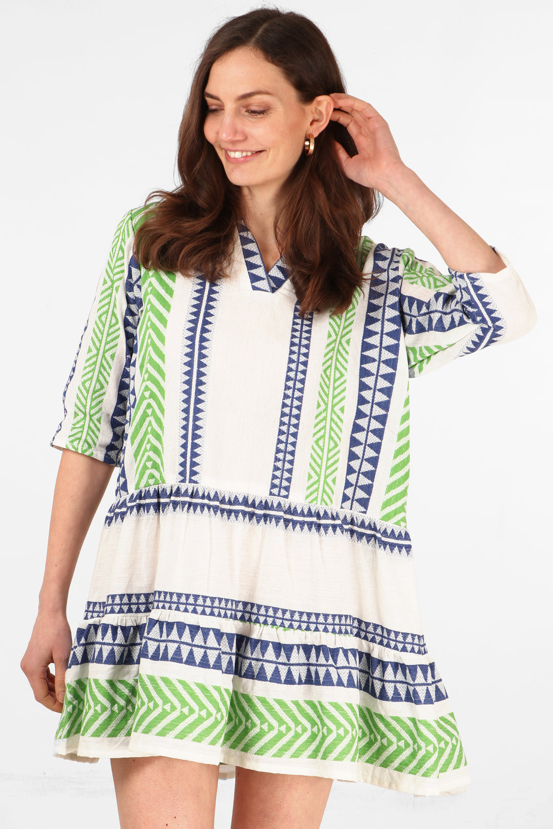 model wearing a green and blue aztec print mini dress with 3/4 sleeves