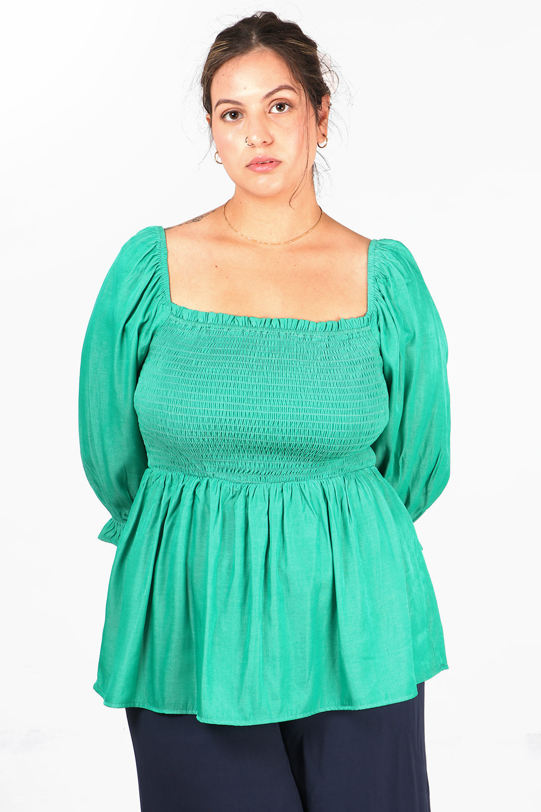 model wearing a green milkmaid top with shirred bodice