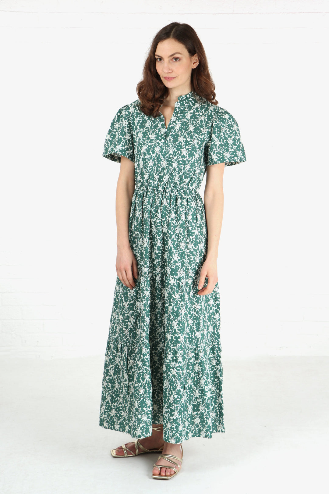 model wearing a short sleeve tiered maxi dress in green and white with an all over floral broderie anglaise detail