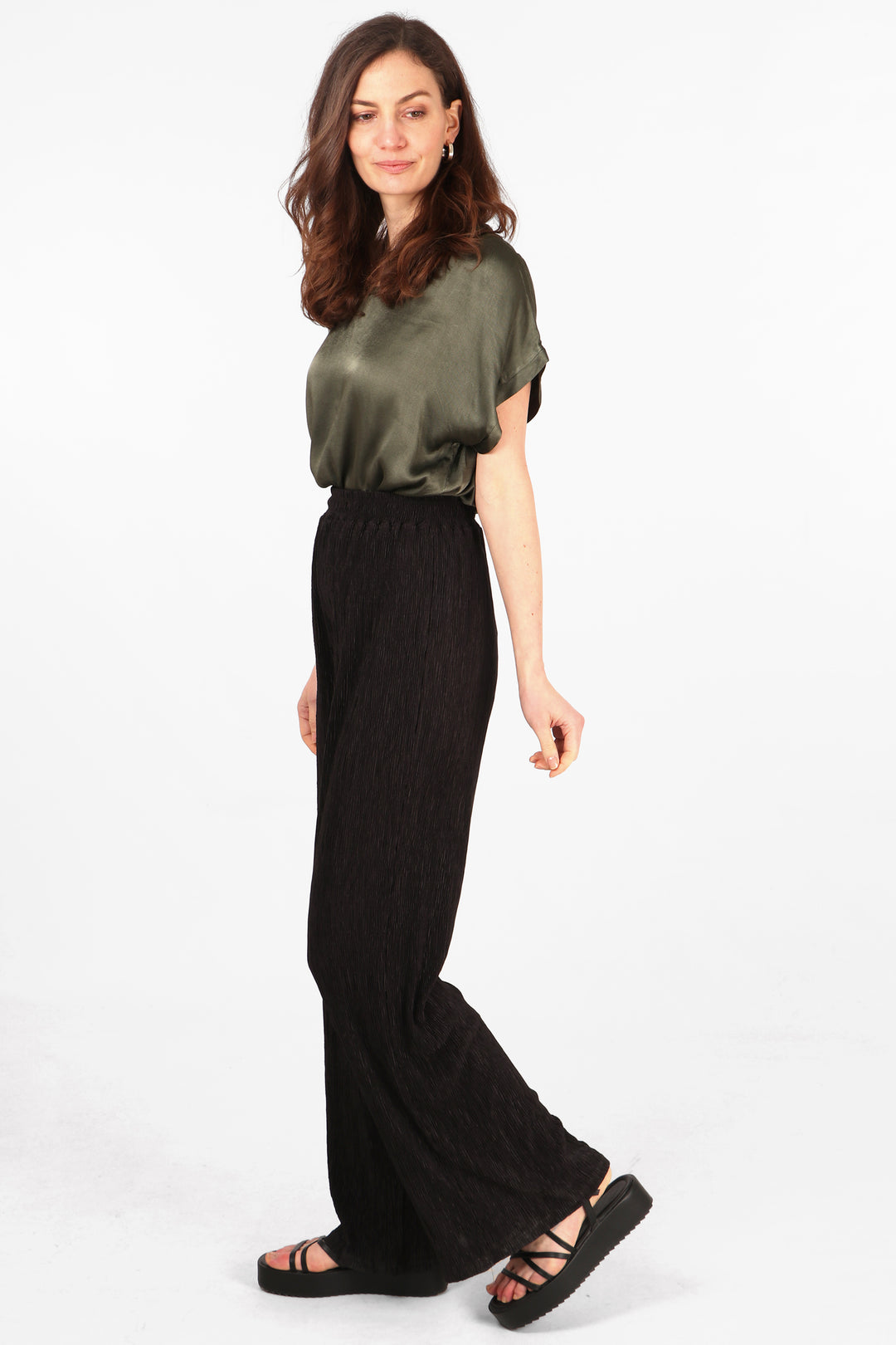 side view of the long black crinkled trousers