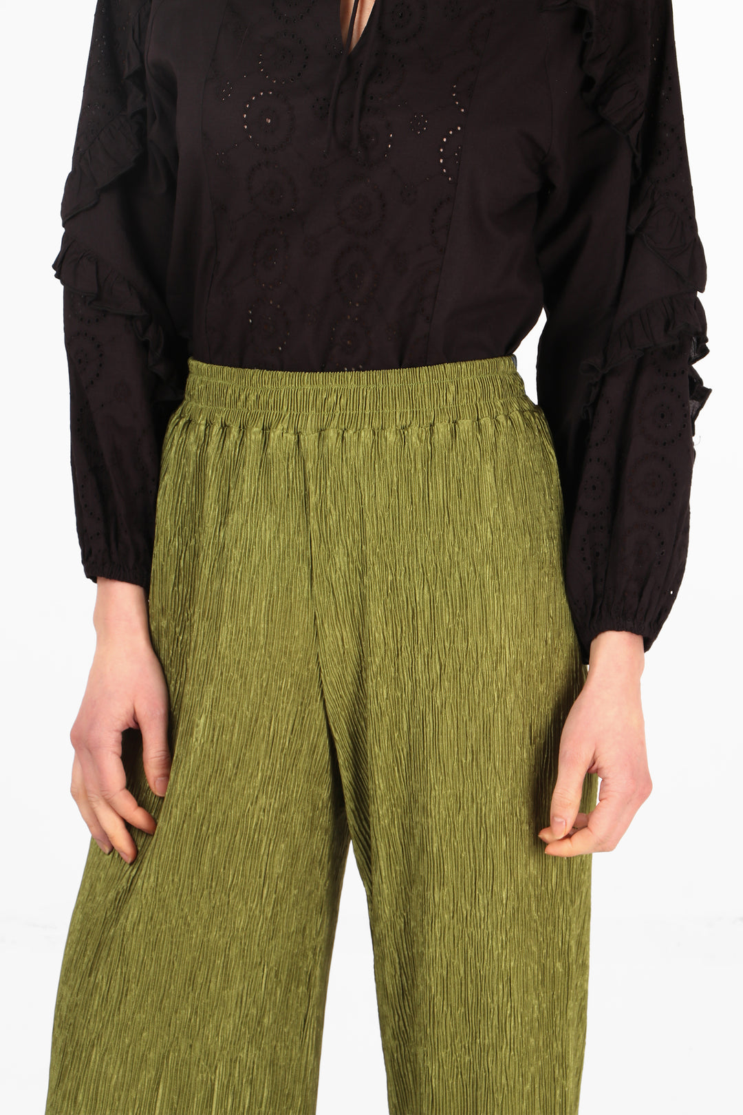 close up of the crinkled crepe material and smocked elasticated waist of these olive green trousers
