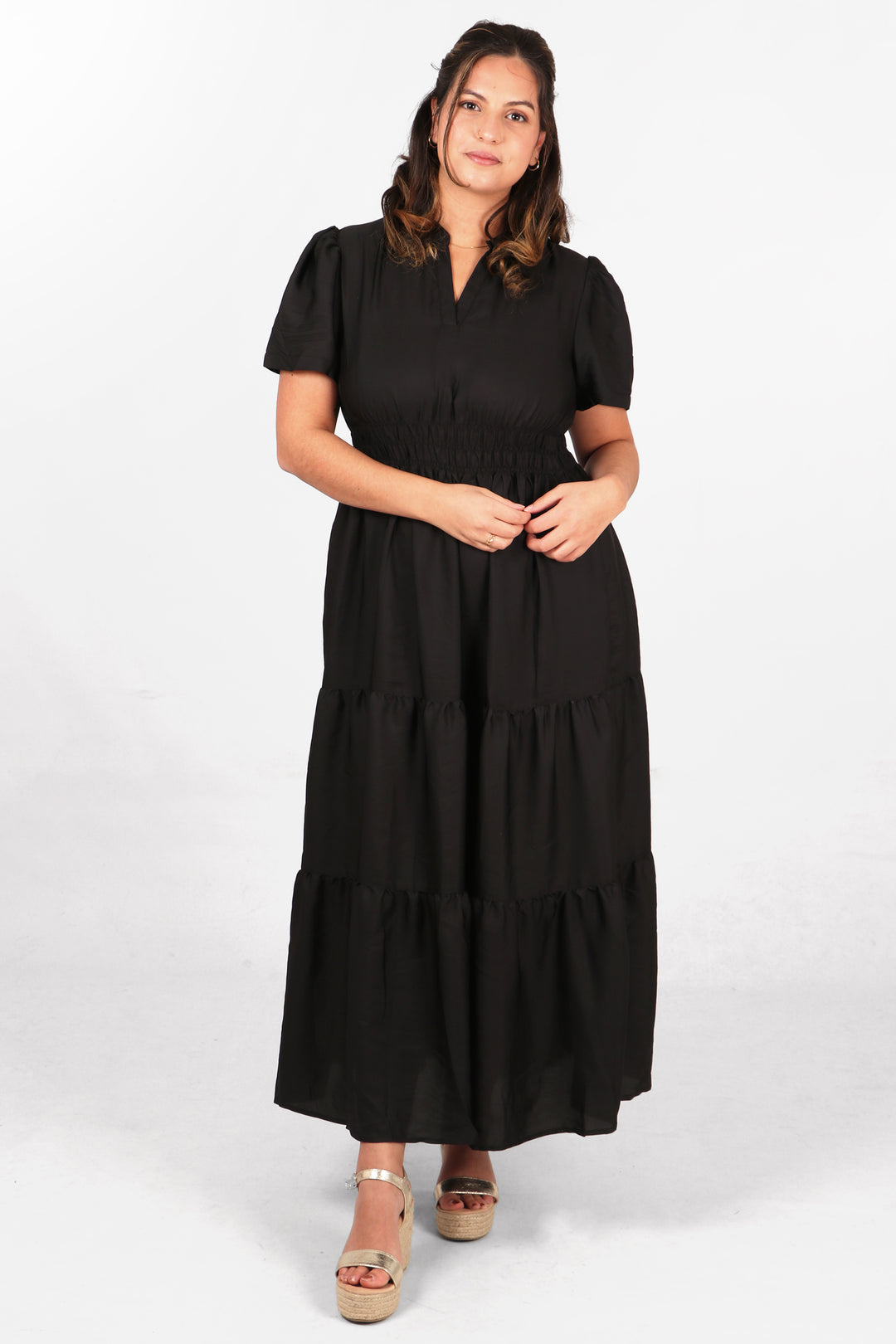 model wearing a black green maxi dress with short sleeves, smocked waist and grandad collar