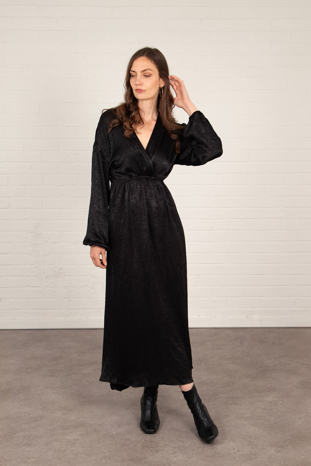 model wearing a long sleeve black maxi dress with a v-neck and faux wrap top