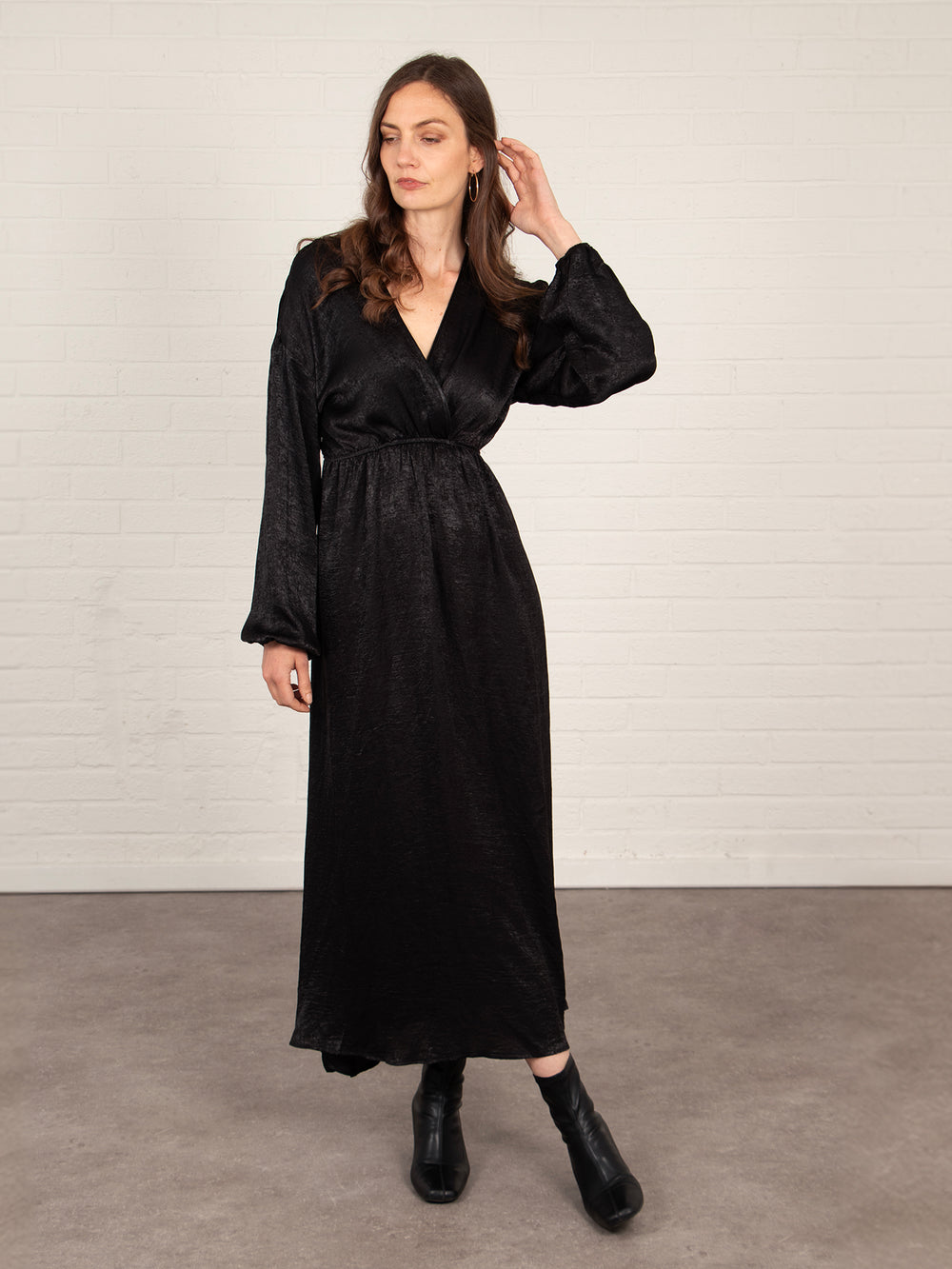 model wearing a long sleeve black maxi dress with a v-neck and faux wrap top