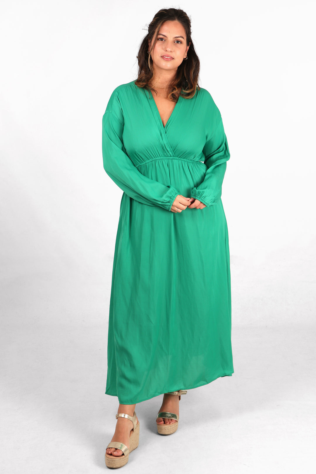 model wearing a plain green long sleeved maxi dress with a faux wrap top and v neck