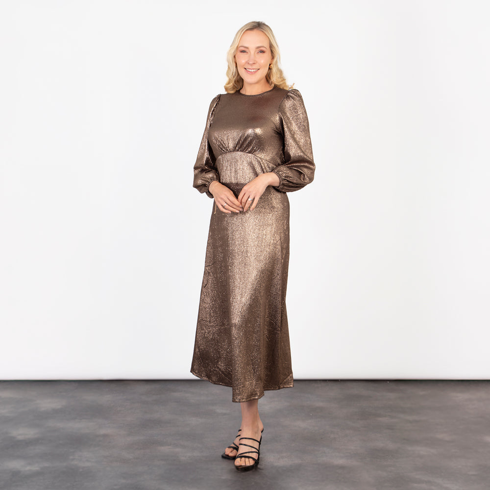 model wearing a bronze coloured metallic long sleeve tea dress