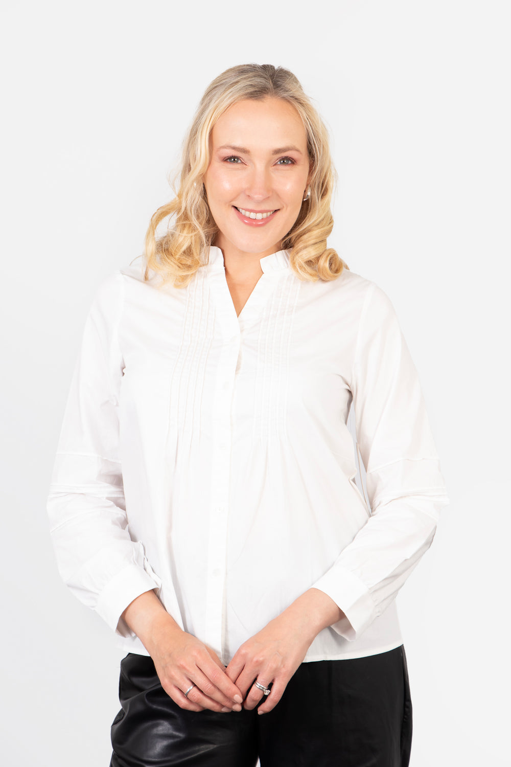 model wearing a white pleated front cotton shirt with button down front fastening