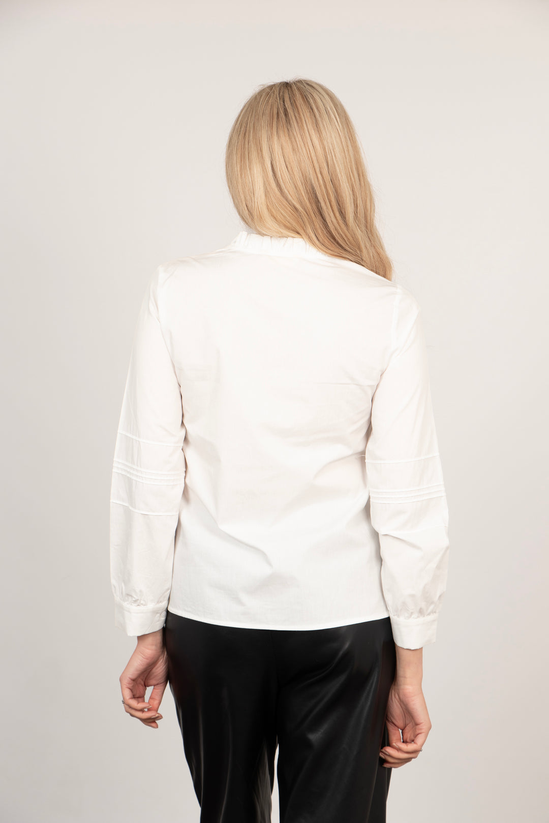 model showing the back of the blouse, showing the hemline which rests on the hips