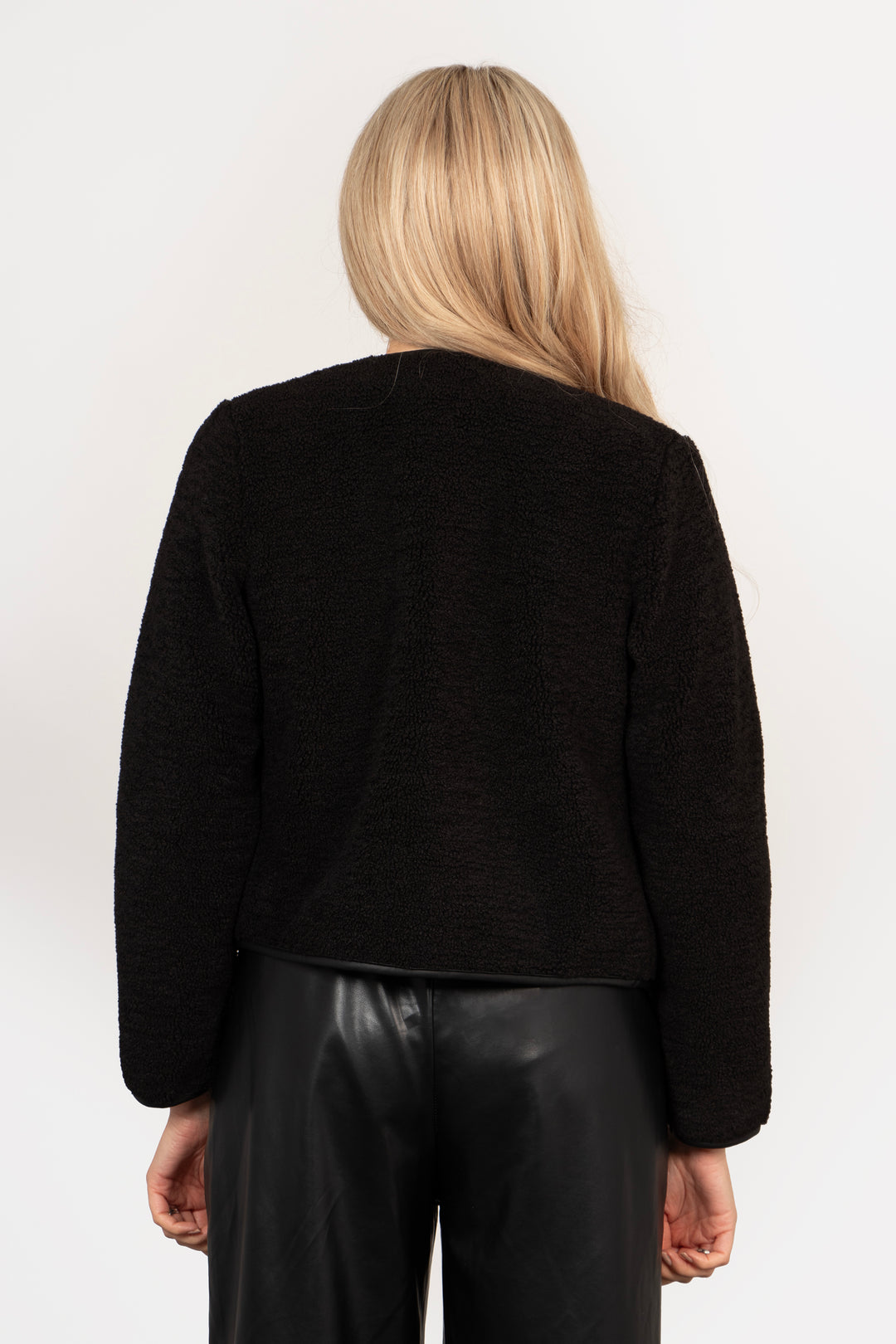 model showing the back of the black fleece jacket, the back is plain and made from borg fleece