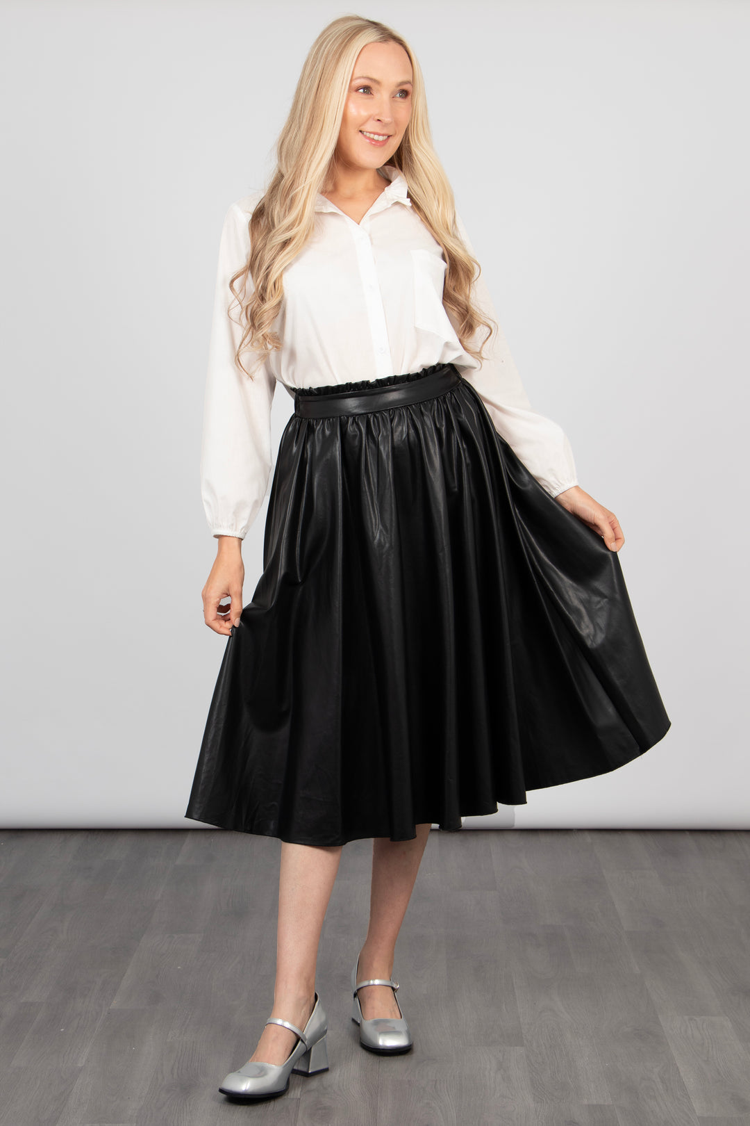 model showing the a-line shape of the black pleather midi skirt