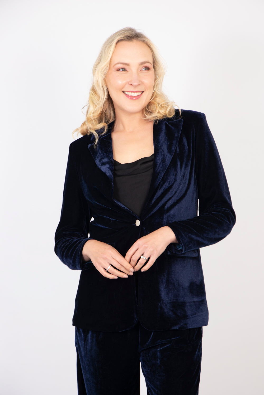 model wearing a plain navy blue velvet blazer jacket with long sleeves and a front button fastening