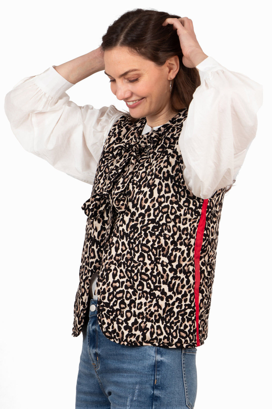 model with her arms raised, showing clearly the red vertical stripe on the side of the gilet. the stripe runs from the base of the armpit to the hemline.