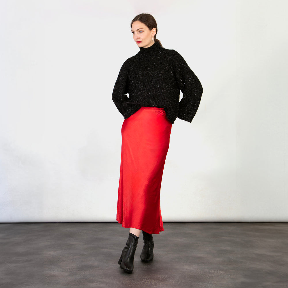 model wearing a midi length red slip skirt with an elasticated waist