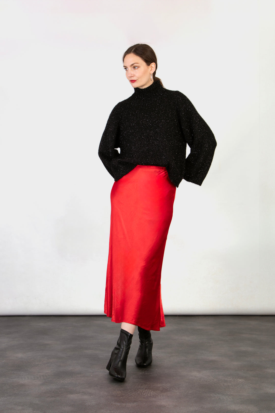 model wearing a midi length red slip skirt with an elasticated waist