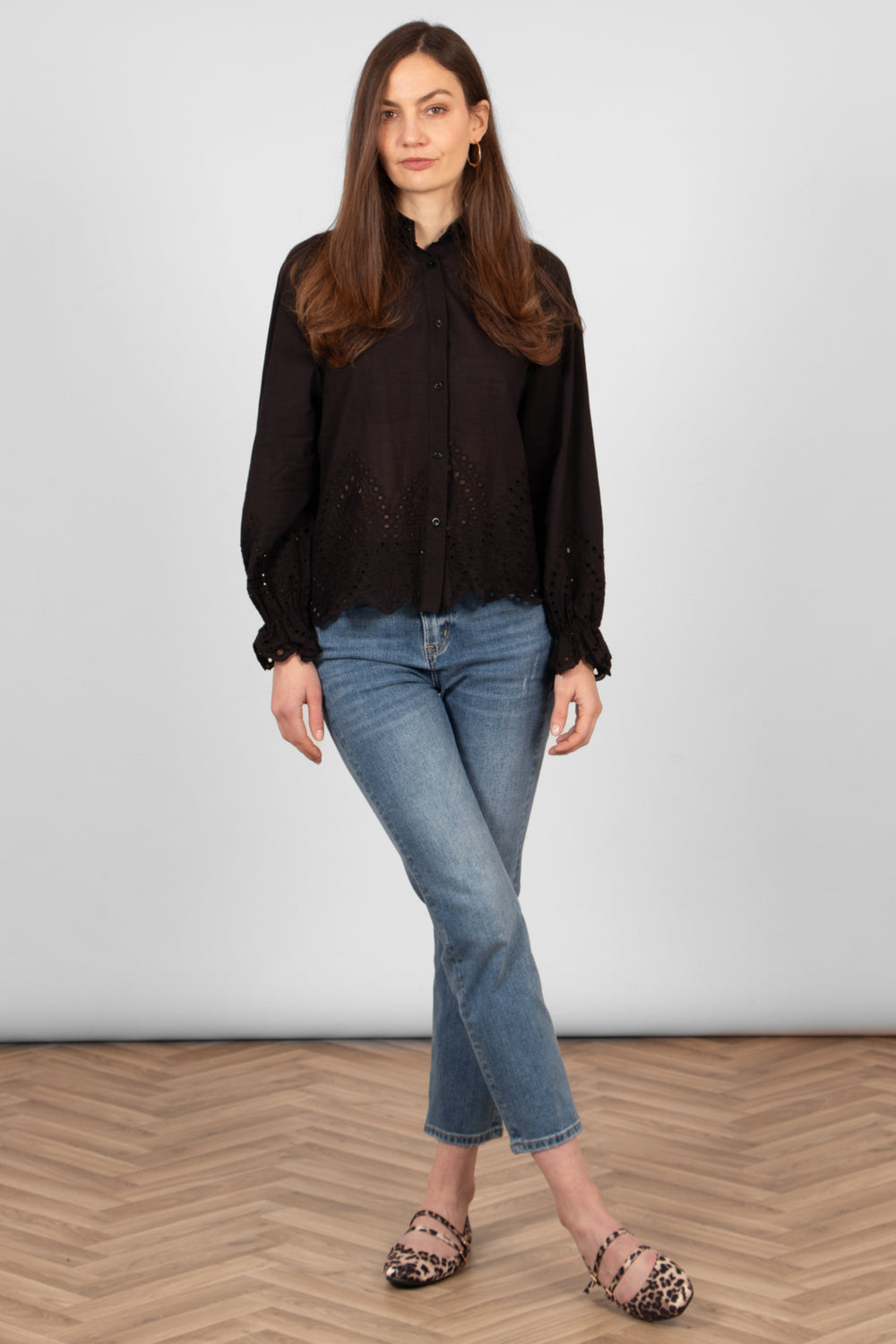 model wearing a black cotton broderie anglaise shirt styled with casual blue jeans and leopard print flats.