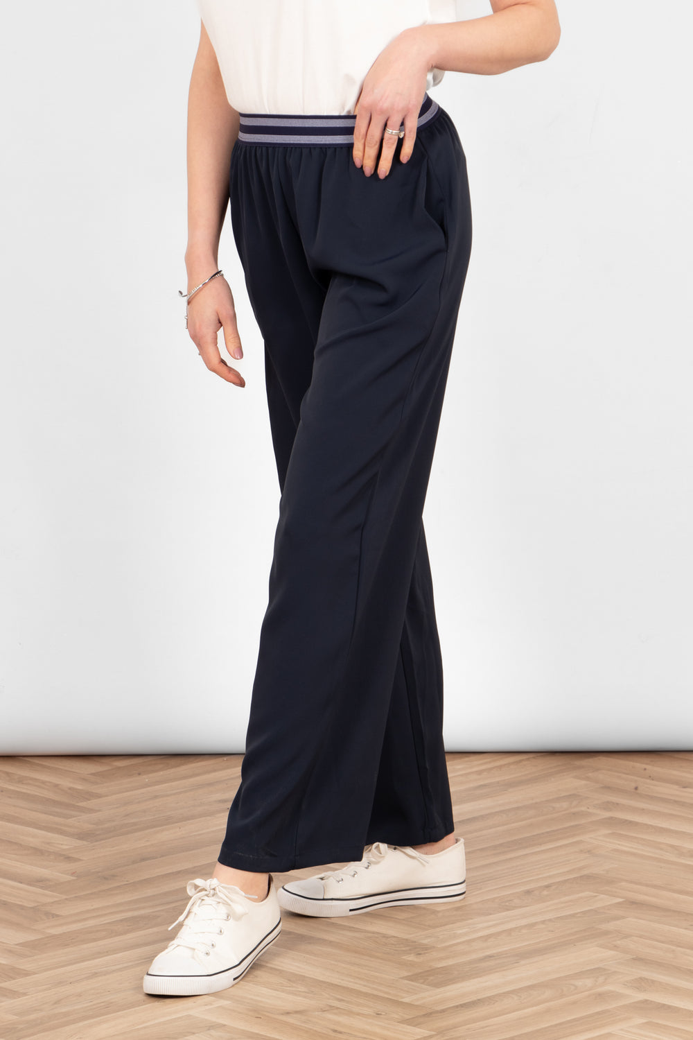 side view of the trousers, showing the pockets and the wide leg design of the piece.