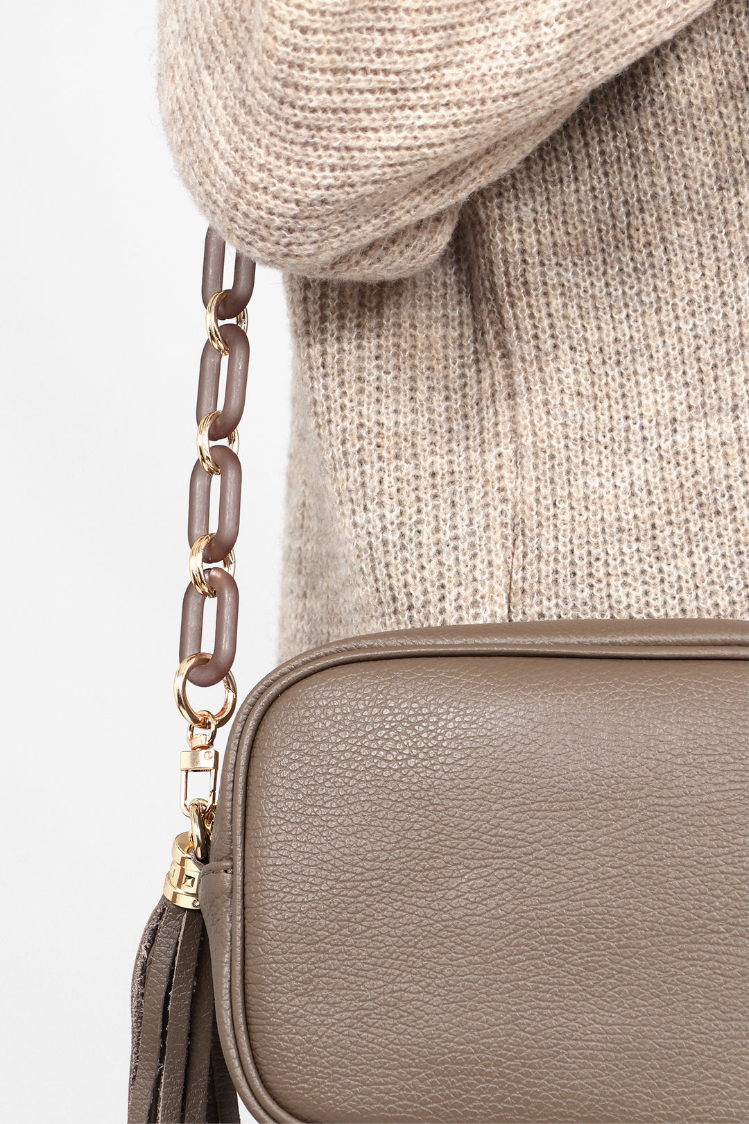 the grey and gold link bag strap attached to a crossbody bag