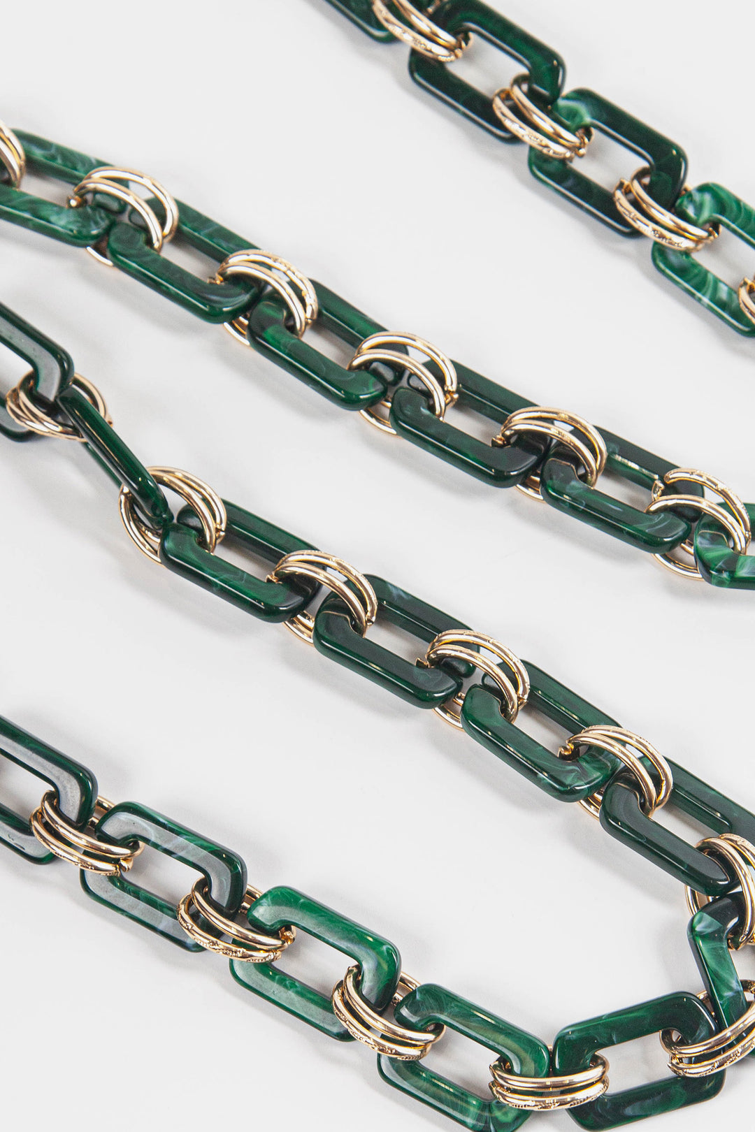 close up of the classic dark green square link acrylic bag strap each link is adjoined by two gold metal hoops